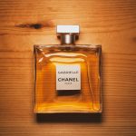 Elegant Chanel perfume bottle displayed on a warm wooden surface, showcasing luxury and style.