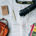 flat lay photography of camera, book, and bag