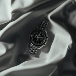 a watch is laying on a white cloth